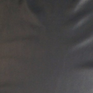May include: A dark gray fabric with a smooth, slightly shiny texture.