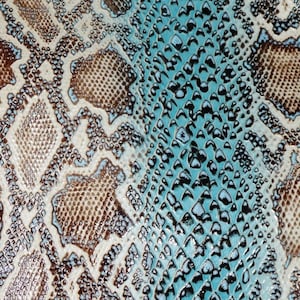 May include: Close-up of a snakeskin pattern fabric with a brown and white pattern on the left side and a blue and black pattern on the right side.