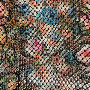 May include: A close-up of a fabric with a snakeskin pattern. The pattern features a variety of colors, including pink, orange, blue, and green, arranged in a mosaic-like design. The scales are outlined in black.