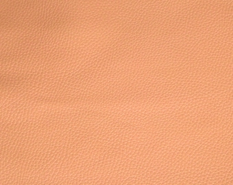 May include: A close-up of a peach-colored textured leather surface.