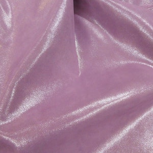 May include: A close-up of a shimmering, lavender fabric. The material has a soft, flowing texture with subtle highlights, creating a lustrous appearance. The fabric's folds and curves add depth and dimension to the image.