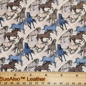 May include: A white fabric with a repeating pattern of brown, blue, and beige horses running. The fabric is measured with a ruler in inches. The text "PeggySueAlso TM Leather" is printed on the ruler.