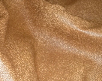 May include: Close-up of a brown leather fabric with a textured surface.