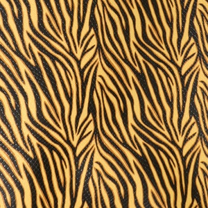 May include: A close-up of a fabric with a black and gold zebra print pattern.