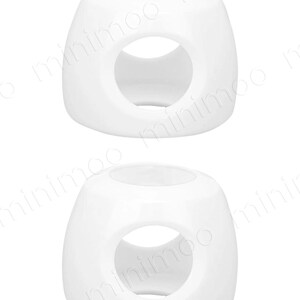 May include: Two white, cube-shaped candle holders. Each holder has a large, circular opening on one side and a smaller opening on the top. The holders are smooth and glossy, with rounded edges.