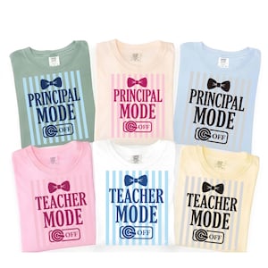 May include: Six t-shirts in different colours, each with a unique design. The shirts feature the phrases "PRINCIPAL MODE" and "TEACHER MODE" with bow tie graphics and the word "OFF". The shirts are light green, cream, light blue, pink, white, and yellow.