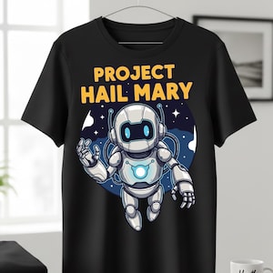 Może przedstawiać: Czarny t-shirt z kresk&oacute;wkowym robotem i ż&oacute;łtym napisem "PROJECT HAIL MARY". Robot jest biało-srebrny z niebieskimi akcentami, na niebiesko-białym tle z gwiazdami. Projekt jest umieszczony na środku koszulki.