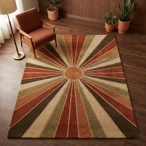 Puede incluir: Una alfombra rectangular con un diseño de rayos de sol en tonos marrones, naranjas, verdes y beige. La alfombra presenta un diseño circular central con líneas radiales, creando un patrón geométrico retro. La alfombra está colocada sobre un suelo de madera.