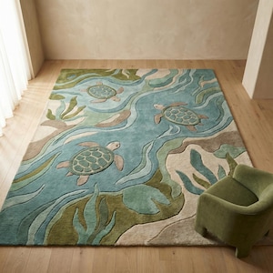 May include: A rectangular rug with a sea turtle design. The rug has a blue background with green and beige accents, depicting an underwater scene with three sea turtles. The turtles have textured green shells and are surrounded by flowing water and aquatic plants.