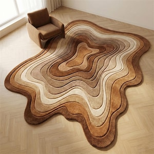 May include: A unique, abstract rug in shades of brown, tan, and cream, resembling a topographical map or flowing liquid. The rug's layered design creates a 3D effect, adding visual interest to any room. A brown armchair sits nearby.