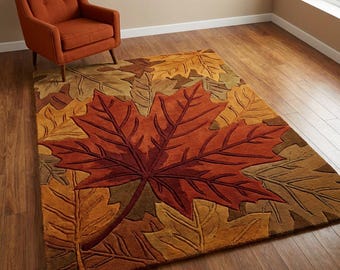 May include: A rectangular area rug with a large, detailed maple leaf design in shades of red, orange, and brown. The rug is surrounded by smaller leaf patterns in various autumnal colors. An orange armchair sits in the upper left corner.