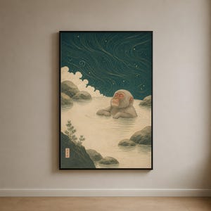 May include: A framed wall art print featuring a Japanese macaque soaking in a hot spring. The scene includes dark teal swirling night skies with stars, light-colored water, grey rocks, and a small pine tree. A red seal with Japanese text is visible.