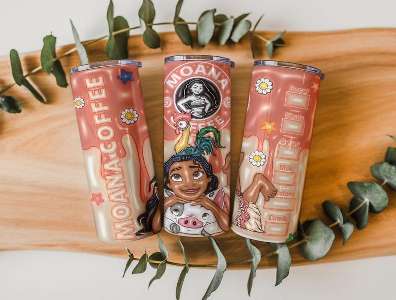 K&ouml;nnte beinhalten: Drei rosa isolierte Becher mit Moana-Designs. Einer zeigt den Text "MOANA COFFEE" und ein Stern- und G&auml;nsebl&uuml;mchenmuster. Die anderen zeigen Moana und ihre Freunde mit einer Kaffee-Rezepttabelle. Die Becher sind mit Zeichentrickfiguren verziert.