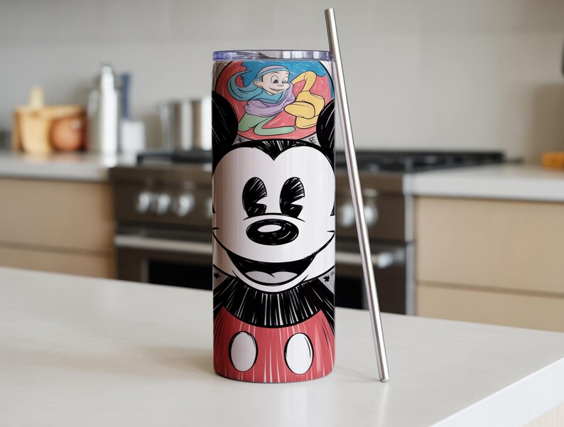 May include: A stainless steel tumbler featuring a smiling Mickey Mouse design. The tumbler has a red and white base with Mickey's iconic shorts. A silver straw is placed next to the tumbler. The top of the tumbler has a colorful illustration.