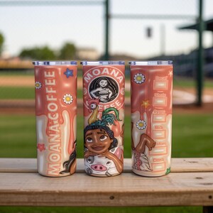 K&ouml;nnte beinhalten: Drei Edelstahlbecher mit korallenfarbenem Hintergrund. Jeder Becher hat ein anderes Design aus dem Film Moana. Einer hat die Worte "Moana Coffee", ein anderer Moanas Bild und der dritte Getr&auml;nkemessungen.