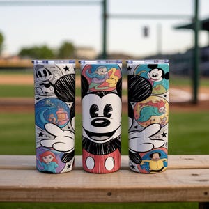 May include: Three stainless steel tumblers featuring Mickey Mouse and other Disney characters. The tumblers have a white background with colorful illustrations of Disney characters and scenes. The tumblers are cylindrical and have a silver lid.