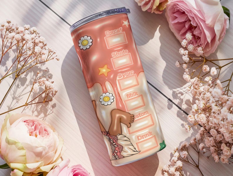 K&ouml;nnte beinhalten: Ein rosa-wei&szlig;er isolierter Becher mit einem Cartoon-Design. Der Becher zeigt die W&ouml;rter "Decaf", "Shots", "Syrup", "Milk", "Custom" und "Drink". Der Becher ist mit G&auml;nsebl&uuml;mchen und einem Stern verziert.