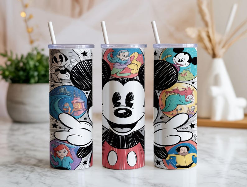 May include: Three stainless steel tumblers with Disney character designs. Each tumbler features a different design, including Mickey Mouse, cartoon scenes, and a white straw. The tumblers are decorated with colorful illustrations and black and white accents.