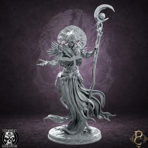 Pode incluir: Uma miniatura de resina cinzenta de uma entidade com túnica, uma mão a cobrir o rosto e um grande toucado circular. A figura segura um livro aberto numa mão e um cajado alto rematado com uma lua crescente e uma esfera na outra.