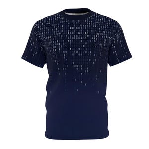 May include: A navy blue t-shirt featuring a digital rain pattern of white binary code. The design transitions from a dense pattern at the top to sparse at the bottom. The shirt has short sleeves and a crew neck.