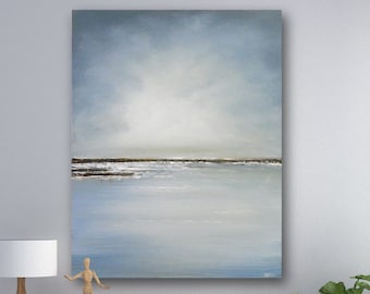 May include: A light blue abstract painting of a seascape with a horizon line and a cloudy sky. The painting is hanging on a white wall above a wooden dresser with a lamp and a wooden figurine.