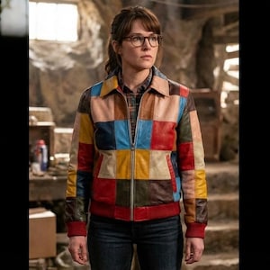 May include: A colorful patchwork leather jacket with a zip-up front. The jacket features a variety of rectangular patches in shades of red, yellow, blue, brown, and pink. The jacket has a collared neckline and red ribbed cuffs and hem.