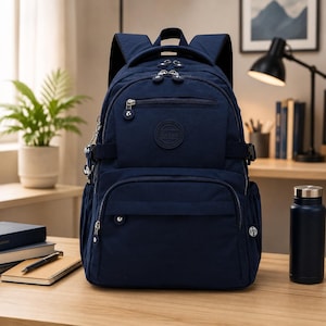 May include: A navy blue backpack featuring multiple zippered compartments, adjustable shoulder straps, and a circular logo patch on the front pocket. The bag includes side pockets and silver-toned metal zipper pulls with small circular decorative charms.