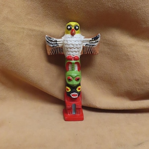 Könnte beinhalten: Eine weiße Keramik-Tasse mit schwarzem Henkel und dem Text "But First, Coffee" in schwarzer, fetter Schrift. Die Tasse steht auf einer weißen Oberfläche.