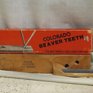 May include: Vintage Colorado Beaver Teeth knife sharpener set. The set includes a red and brown box with the text "COLORADO BEAVER TEETH" and "THE BEST FRIEND A DULL EDGE EVER HAD". The set also includes sharpening rods and a wooden sharpening tool.
