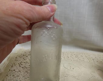 May include: A clear glass bottle with a textured surface and the words "M.P. Wine" embossed on the side.