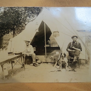 VENTA Postal de fotografía real de un campamento de cazadores antiguos con tienda para perros y rifle RPPC