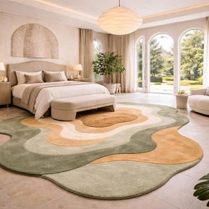May include: A bedroom with a large, wavy area rug in shades of green, tan, and cream. The room features a bed, bench, and armchair, with large windows and a neutral color palette. A large, round light fixture hangs from the ceiling.