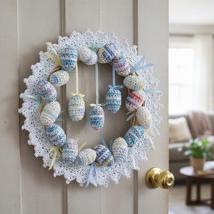 May include: A handmade Easter wreath featuring crocheted eggs in pastel colors, accented with ribbons. The wreath is set against a white crocheted lace background, creating a festive and decorative piece for the holiday season.