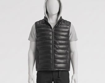 May include: A black puffer vest with a full-length zipper, worn over a gray t-shirt. The vest has a quilted design and a stand-up collar. The mannequin also wears a gray hooded sweatshirt and black pants.