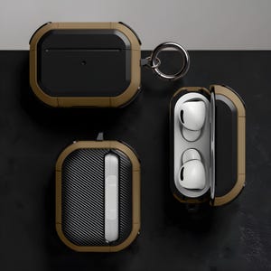 May include: Protective case for wireless earbuds in olive green and black. The case is shown closed, open with earbuds inside, and with a carbon fiber design. A silver metal ring is attached to the case.