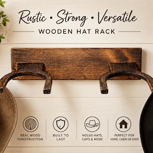 May include: A dark brown wooden hat rack with two curved hooks for storage. The text reads: Rustic Strong Versatile WOODEN HAT RACK, REAL WOOD CONSTRUCTION, BUILT TO LAST, HOLDS HATS, CAPS & MORE, PERFECT FOR HOME, CABIN OR SHOP.