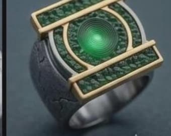 Puede incluir: Un anillo con una piedra preciosa verde circular central con anillos concéntricos, enmarcada por barras rectangulares doradas e incrustaciones verdes texturizadas. La banda tiene un acabado oscuro, desgastado y agrietado en los laterales.