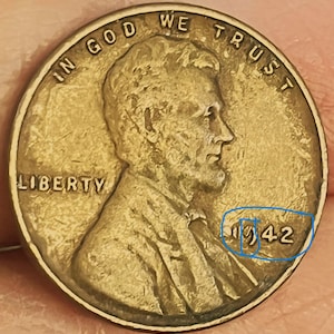 Puede incluir: Primer plano de un centavo Lincoln de 1942 de color bronce. La moneda presenta el perfil de Abraham Lincoln, con las palabras "IN GOD WE TRUST" y "LIBERTY" visibles. El año "1942" también es visible.
