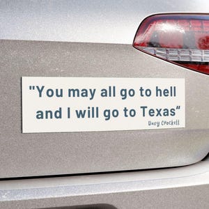 May include: A white rectangular bumper sticker with the quote "You may all go to hell and I will go to Texas" attributed to Davy Crockett. The sticker is affixed to the rear of a silver car.