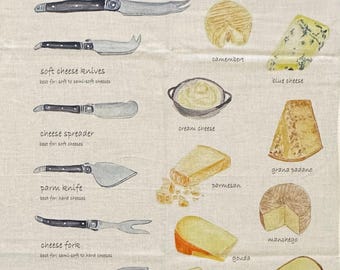May include: A cream-colored kitchen towel featuring a Cheese Knife Guide illustration. It displays various cheese knives with black handles and labels for soft cheese knives, spreaders, parm knives, forks, chisels, and cleavers, alongside drawings of brie, camembert, blue cheese, cream cheese, grana padano, parmesan, manchego, gouda, gruyère, comté, and cheddar.