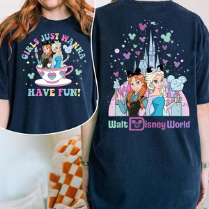 May include: Navy blue t-shirt featuring a colorful graphic of Anna and Elsa from Frozen, with the text "Girls Just Wanna Have Fun!" on the front and "Walt Disney World" on the back. The design includes Mickey Mouse icons and a castle.