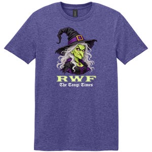 May include: A heathered purple short-sleeve t-shirt featuring a graphic of a green-skinned witch with long white hair wearing a black hat. Below the witch, the text reads RWF and The Tangi Times in white and light green lettering.