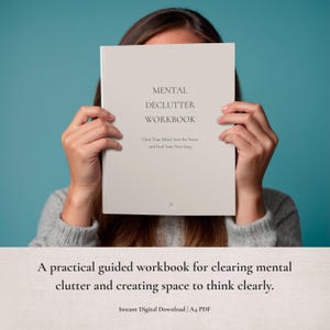 Könnte beinhalten: Ein hellbeiges Arbeitsbuch mit dem Titel MENTAL DECLUTTER WORKBOOK in dunkler Schrift. Unter dem Titel steht der Text Clear Your Mind, Sort the Noise, and Find Your Next Step. Das Cover zeigt ein kleines Logo in der unteren Mitte.