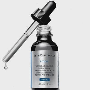 May include: A skincare product bottle with a dropper. The bottle is dark with a white and blue label that reads "SKINCEUTICALS P-TIOX WRINKLE-MODULATING PEPTIDE SERUM." The dropper is inserted into the bottle, with a drop of serum suspended. The bottle contains 30 ml / 1 fl oz.