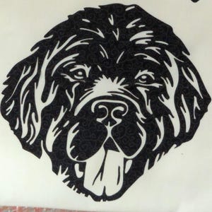 May include: Black and white silhouette of a dog's head with a long snout and floppy ears. The dog's tongue is sticking out.