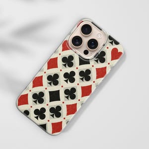 May include: A phone case with a playing card design. The case features a repeating pattern of red diamonds, black clubs, black squares, and red hearts on an off-white background. The phone case has a clear border.