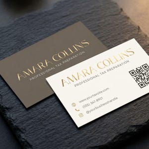 Peut inclure: Deux cartes de visite avec des lettres dorées sur un fond sombre. Les cartes indiquent "AMARA COLLINS PROFESSIONAL TAX PREPARATION". Une carte est de couleur claire, l'autre est plus foncée. La carte claire comprend un code QR et des coordonnées.