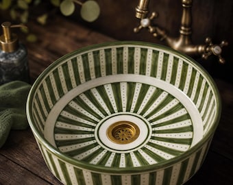 May include: A round ceramic vessel sink featuring a hand-painted pattern of vertical dark green stripes and white dotted lines. The basin has a smooth, glossy finish and includes a central circular brass drain fixture with a decorative perforated design.
