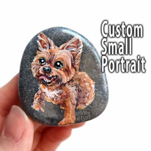 May include: A hand-painted portrait of a small brown and white dog on a grey stone. The stone is painted with the words "Custom Small Portrait" and "Rainbow of Crazy".