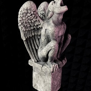 K&ouml;nnte beinhalten: Graue Stein-Wasserspeier-Statue mit gro&szlig;en, detaillierten Fl&uuml;geln, die auf einem quadratischen Sockel sitzt. Die Statue hat einen offenen Mund und eine verwitterte, rissige Textur. Der Hintergrund ist schwarz.